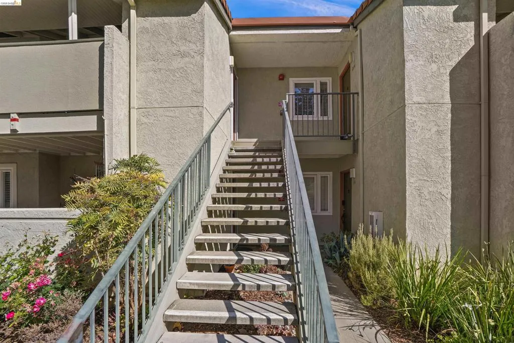 Exterior staircase with metal railings leading to a second-story entrance