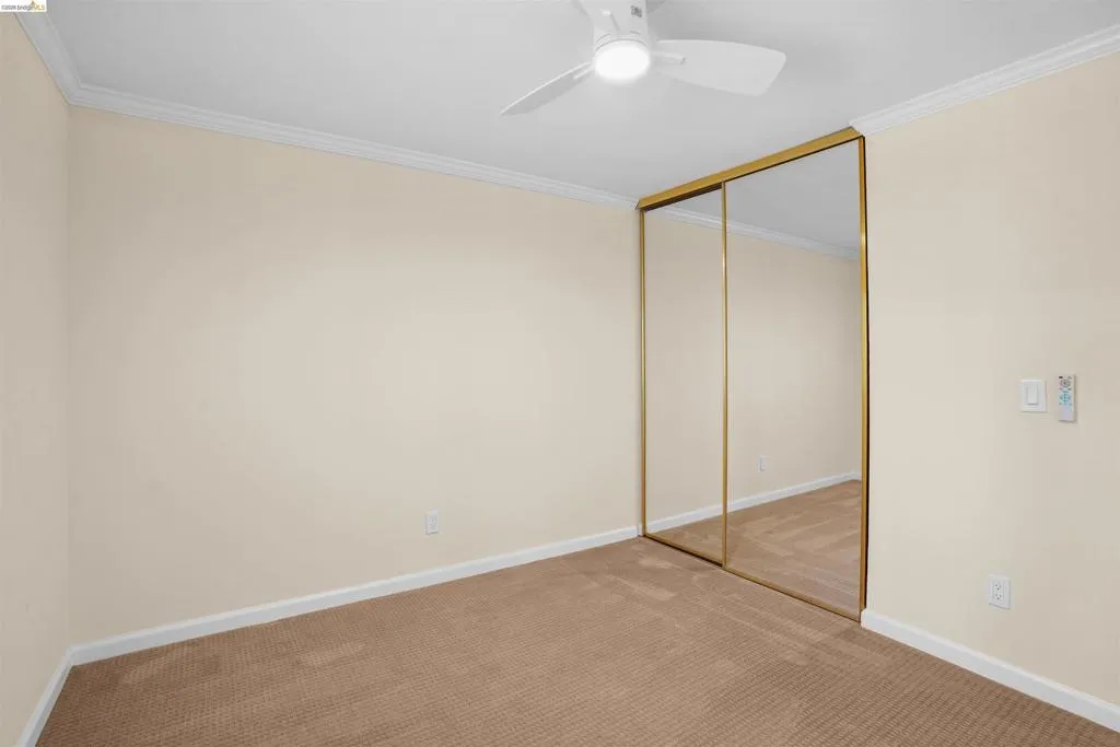 Wall-to-wall carpeting in a neutral tone, complemented by a white ceiling and crown molding