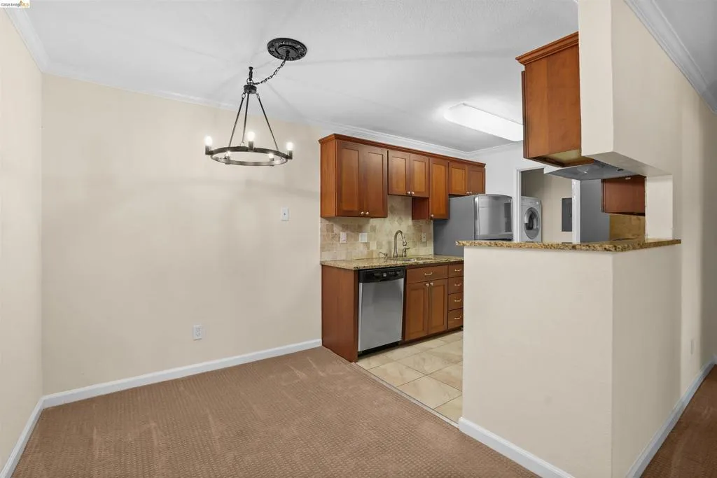 Dining area featuring a circular chandelier with an adjacent kitchen