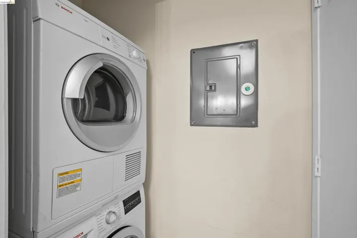 Stacked laundry appliances with a front-loading dryer and a lower front-loading washer