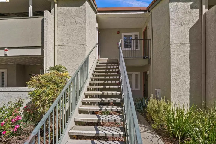 Exterior staircase with metal railings leading to a second-story entrance