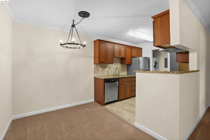 Dining area featuring a circular chandelier with an adjacent kitchen