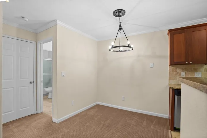 Dining area featuring neutral wall paint, crown molding, and a chandelier with a decorative ceiling medallion