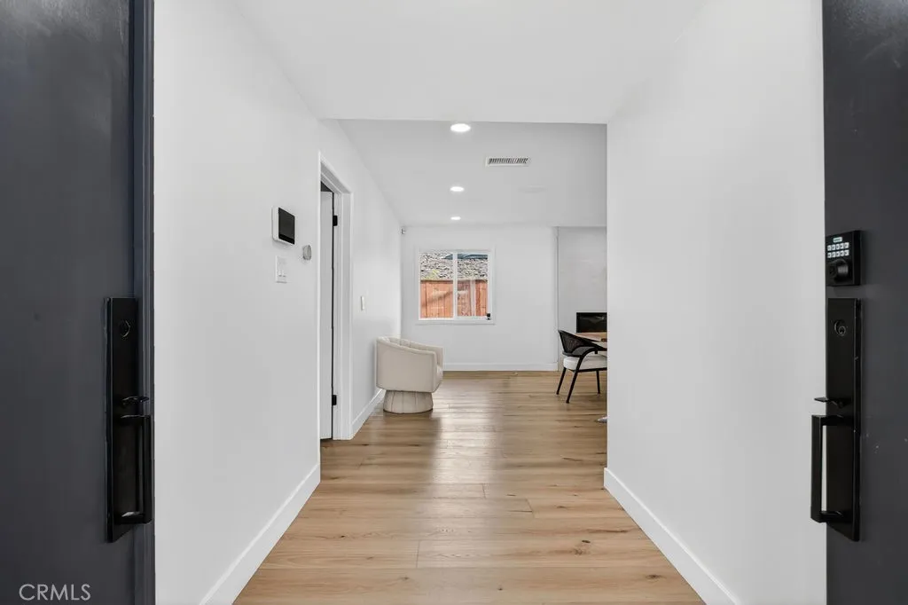 Wide and sleek foyer entry with recessed lighting and premium flooring