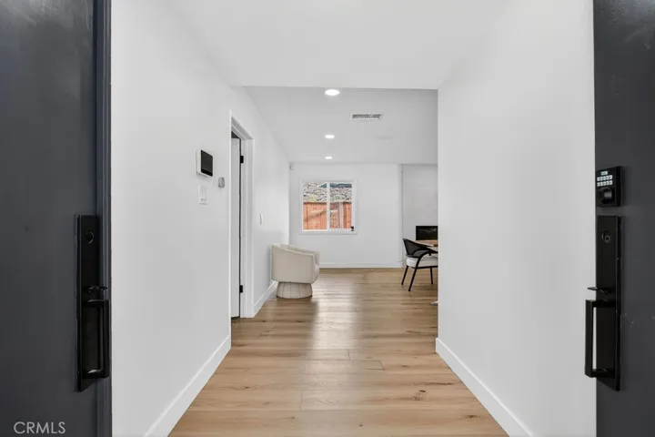 Wide and sleek foyer entry with recessed lighting and premium flooring