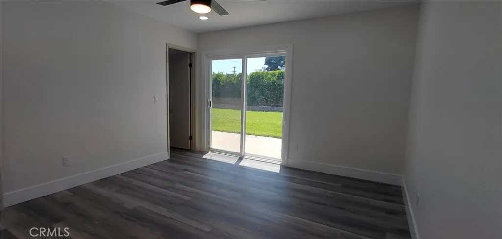 In primary bedroom looking toward backyard patio/slider an ensuite bathroom doorway