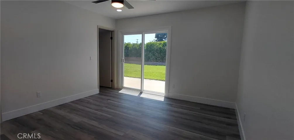 In primary bedroom looking toward backyard patio/slider an ensuite bathroom doorway