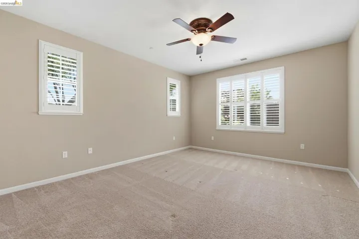 Neutral-toned interior room featuring carpeted flooring and light beige walls