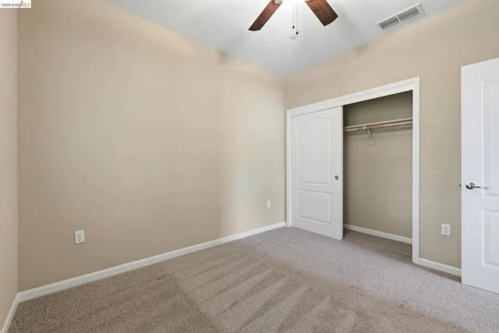 Neutral-toned walls and plush patterned carpeting define this room
