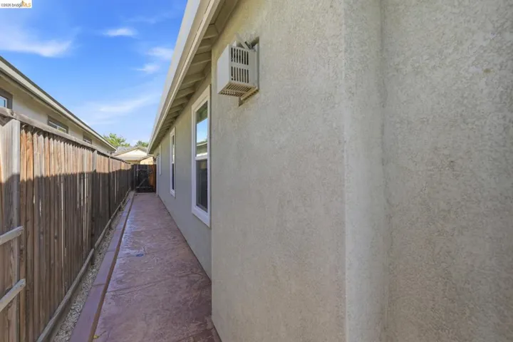 Stamped concrete pathway alongside a stucco exterior