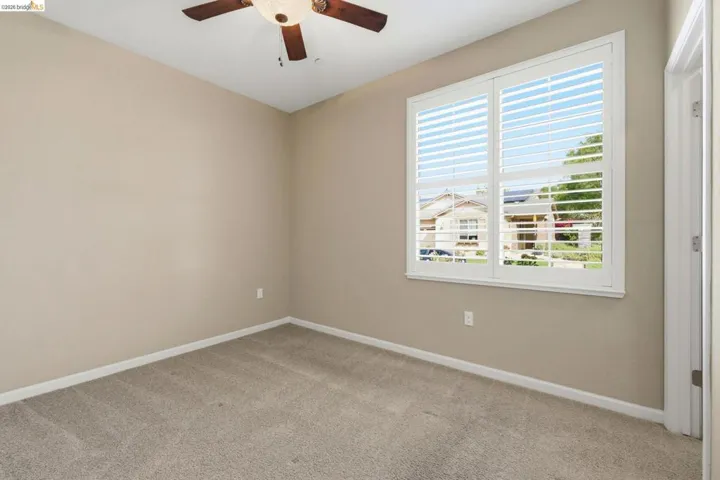 Neutral-toned interior with light carpet flooring and white baseboards