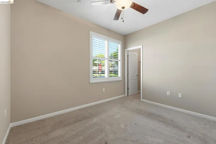Neutral-toned room featuring light beige walls and complementing carpet flooring