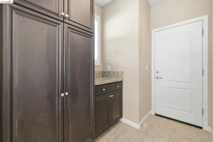 Expansive dark wood-finish cabinetry featuring white knobs, complemented by a granite countertop