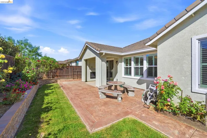Expansive stamped concrete patio featuring a covered outdoor area