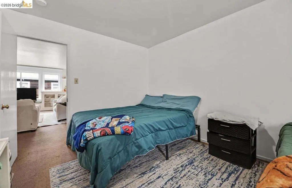 Carpeted room with a doorway opening to an additional space