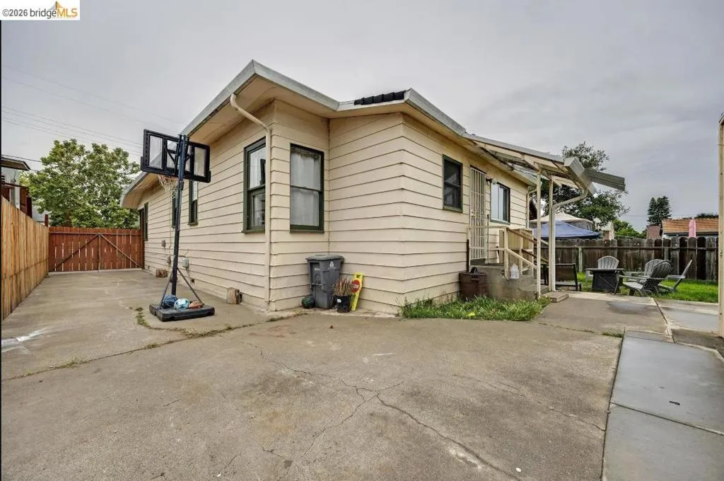 Exterior featuring horizontal siding, multiple windows, and a concrete patio