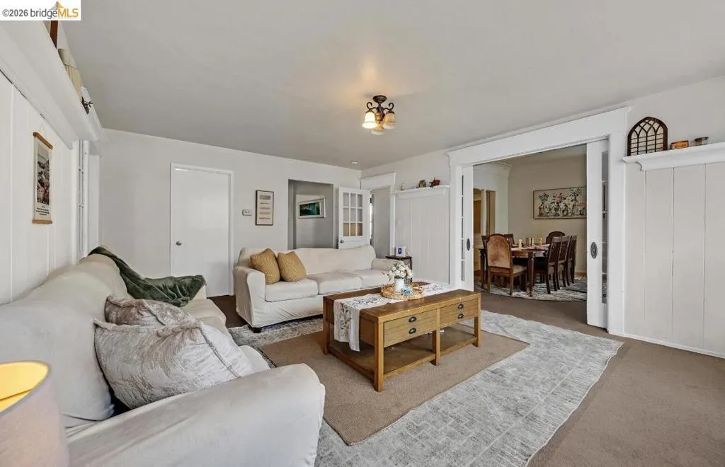 Spacious living area featuring neutral walls and carpet flooring