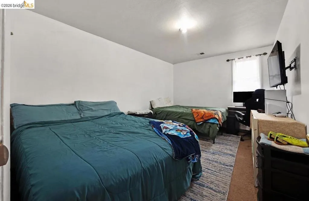 Bedroom featuring a light fixture, single window, and carpeted flooring