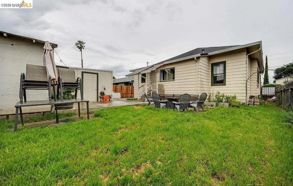 Expansive green lawn with a detached storage shed featuring a white door