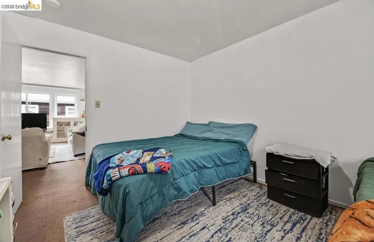 Carpeted room with a doorway opening to an additional space