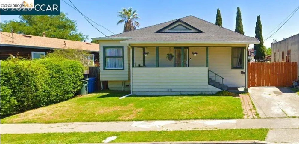 Single-story home featuring a covered front porch, a gabled roofline with a decorative vent, and a front lawn