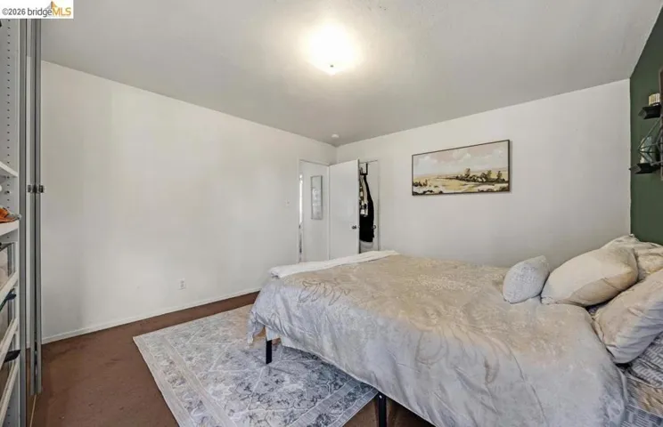 Room featuring white walls, a contrasting dark green accent wall, and brown carpeting