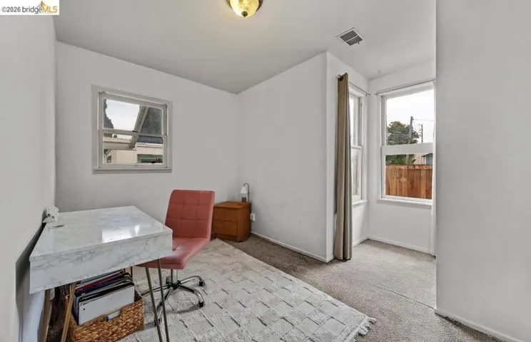 Bright room featuring multiple windows, carpet flooring, and a flush mount ceiling light fixture
