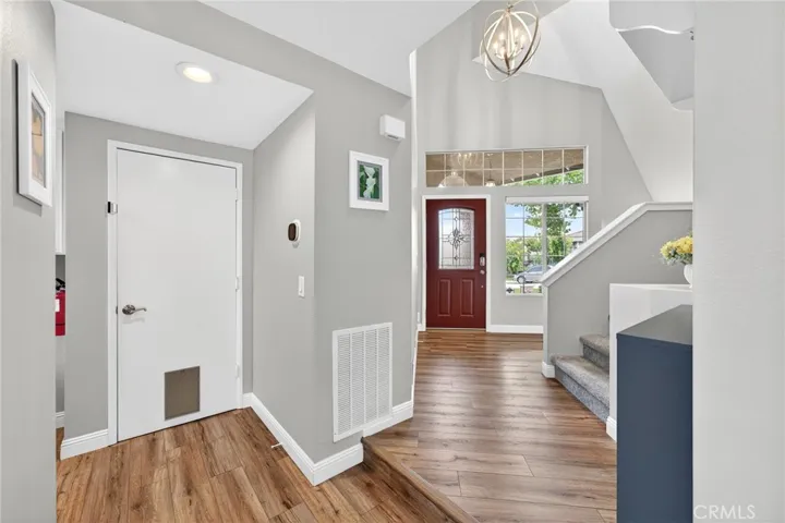 Hallway going to front door, garage and stairs