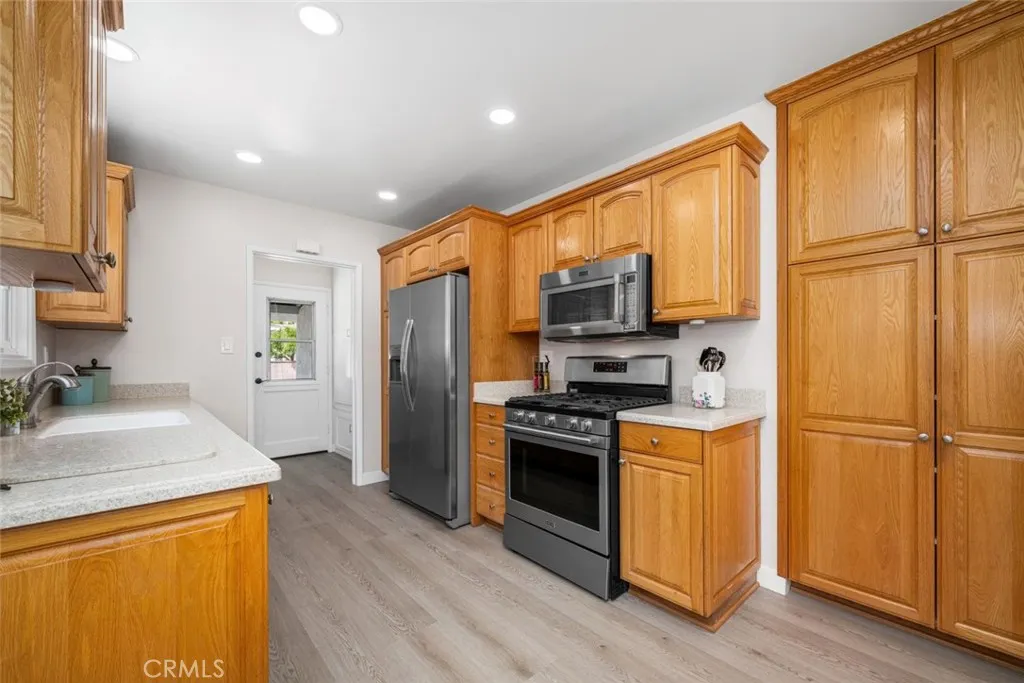 Abundant pantry storage complements the kitchen's suite of appliances, including a gas range, microwave, dishwasher, and refrigerator.