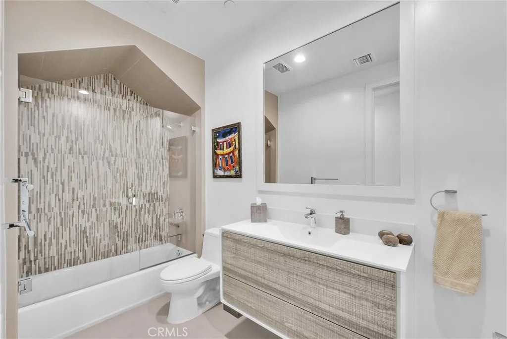 Upper hallway bathroom with custom cabinetry and tile