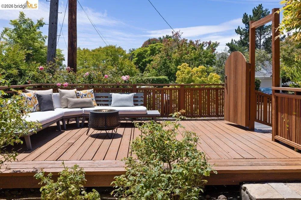 Expansive wood deck with perimeter railing and a tall wooden gate