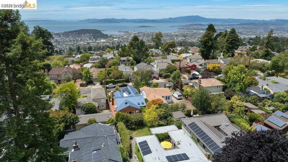 Panoramic neighborhood vista featuring a distant bay and city skyline