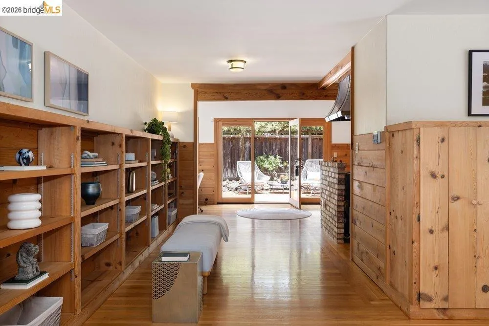 Hardwood flooring extends throughout the space, complemented by extensive built-in shelving and wood paneling