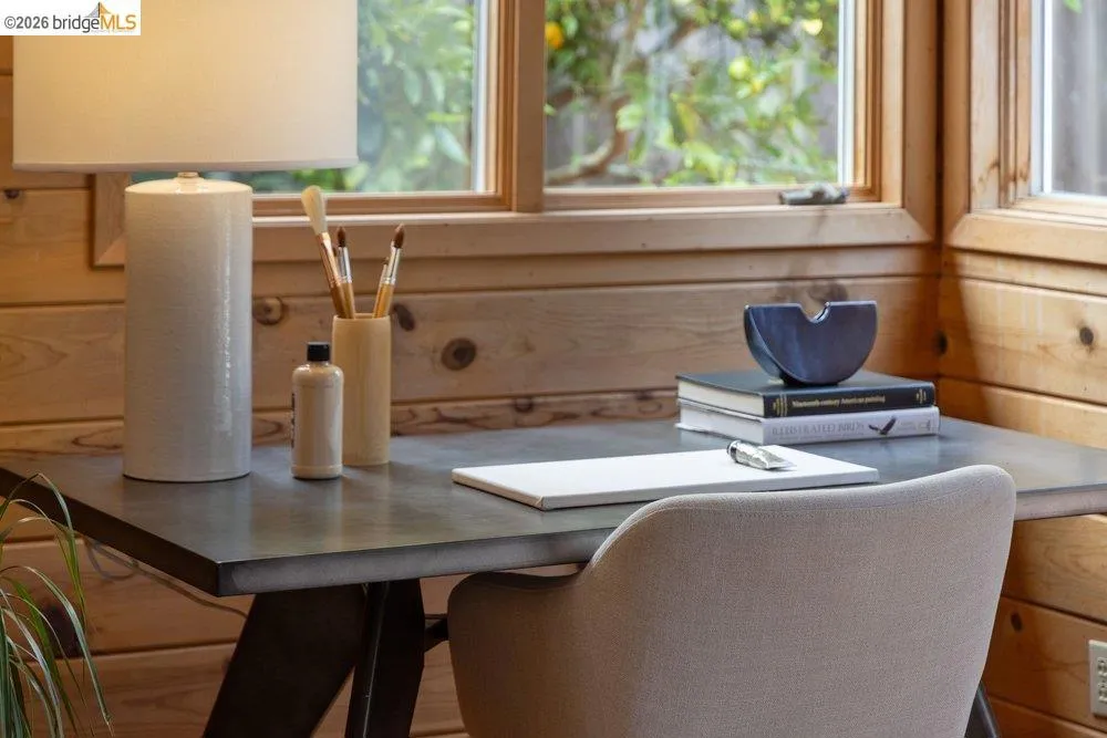 Corner workspace featuring wood-panel walls and two large windows
