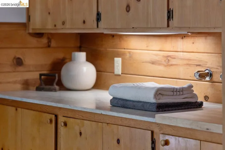 Custom knotty pine cabinetry featuring wood knobs and integrated under-cabinet lighting