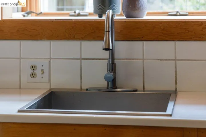Undermount stainless steel sink with a single-handle faucet, set into a light-toned countertop