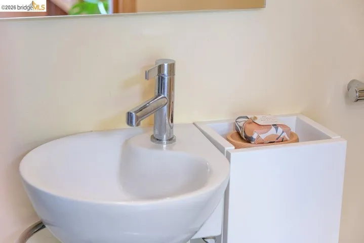 Modern white ceramic vessel sink with a polished chrome faucet, set against a light-toned wall