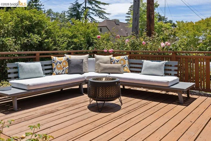 Expansive wood deck with a perimeter wood railing and surrounding mature landscaping