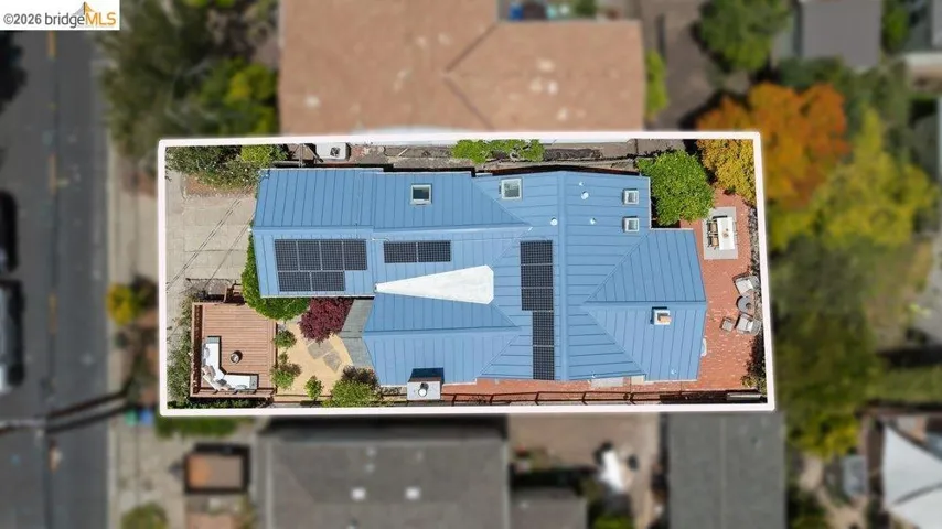 Modern roofline featuring a blue metal roof with multiple solar panel arrays