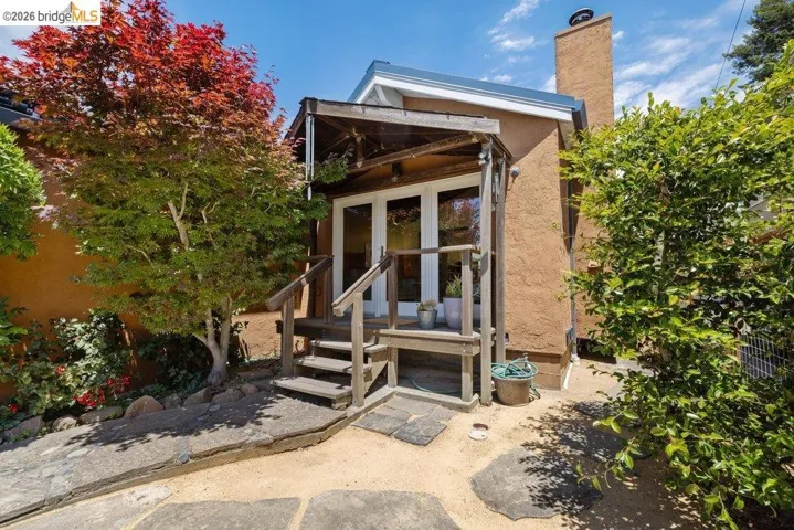 Private exterior entry with wood deck and steps