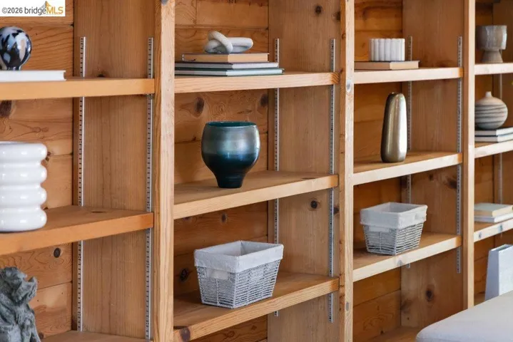 Integrated wooden shelving system featuring adjustable shelves and natural wood-finish paneling