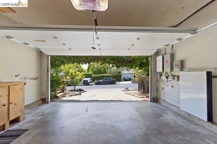 Garage space featuring a concrete floor, an automatic overhead door, and built-in energy storage systems