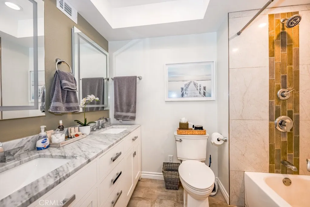 Hall Bath custom vanity cabinets hold two sinks with lighted mirrors, rain shower head, custom tile accents