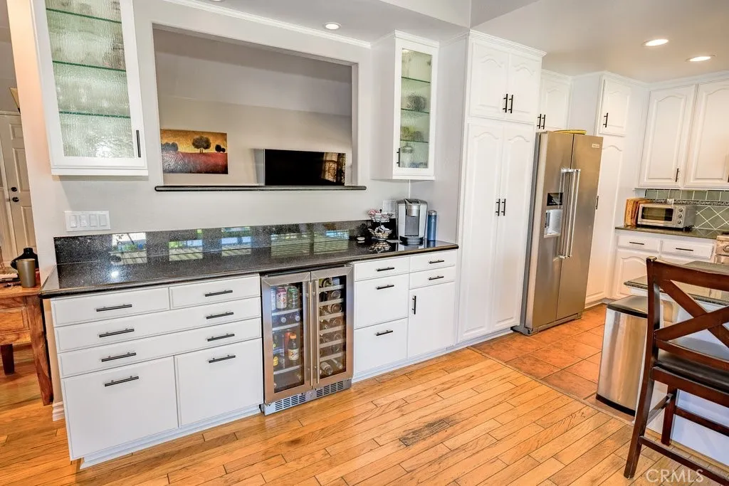 Custom Bar area with recessed lighting inside the cabinets. Dual Zone Wine and Drink refrigerator, custom drawers hold large bottles, printer and file cabinets for easy work at home area.