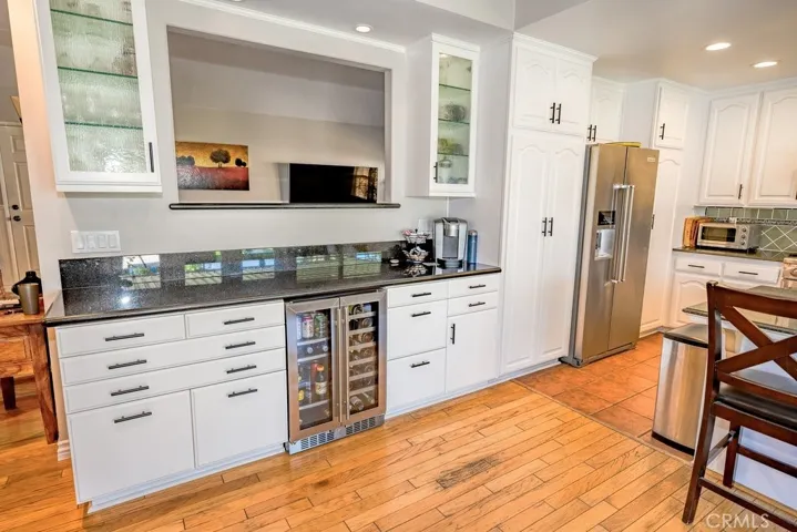 Custom Bar area with recessed lighting inside the cabinets. Dual Zone Wine and Drink refrigerator, custom drawers hold large bottles, printer and file cabinets for easy work at home area.
