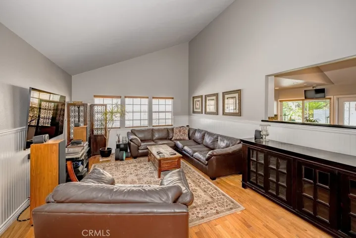 Formal Living Room. Engineered wood flooring, Wainscot siding, Opening to Kitchen area, Neutral Paint.