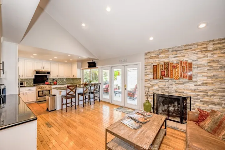 Stone Accent Wall with Fireplace in the Family Room with views to the Kitchen and French Doors leading to the covered patio