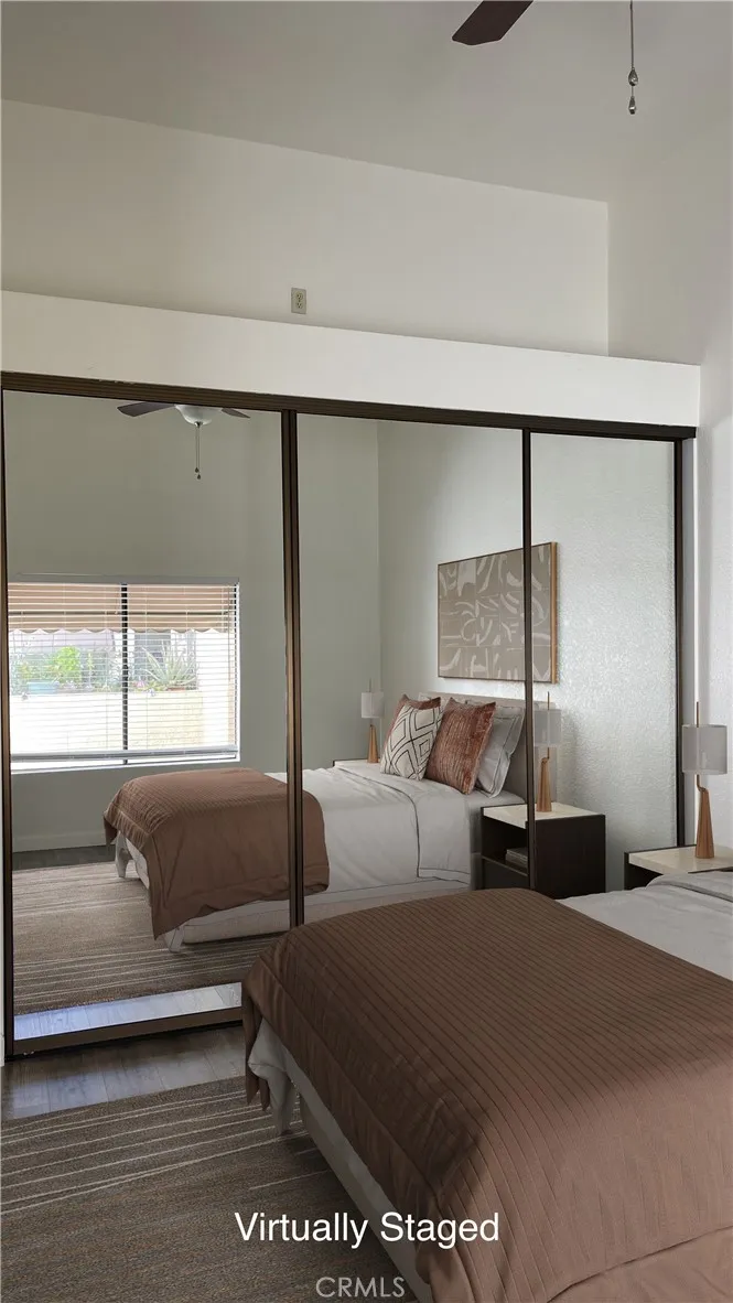 Virtually Staged Primary Bedroom - large closet space with closet organizers, vaulted ceiling and a ceiling fan.