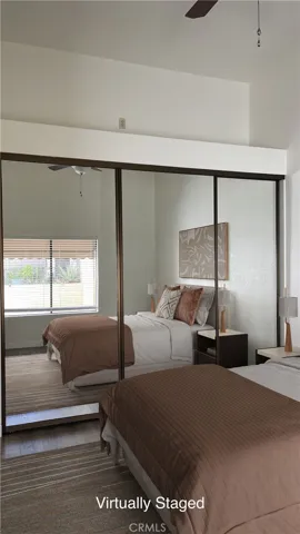 Virtually Staged Primary Bedroom - large closet space with closet organizers, vaulted ceiling and a ceiling fan.