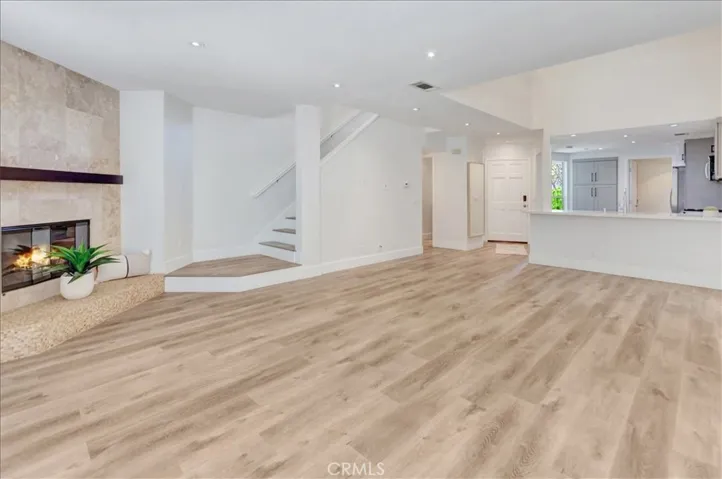 Living Room looking towards beautiful white and wood staircase, and open kitchen.